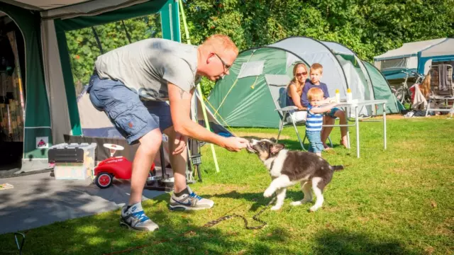 Man met hond en gezin bij tent op Vakantiepark De Krim VVV Texel