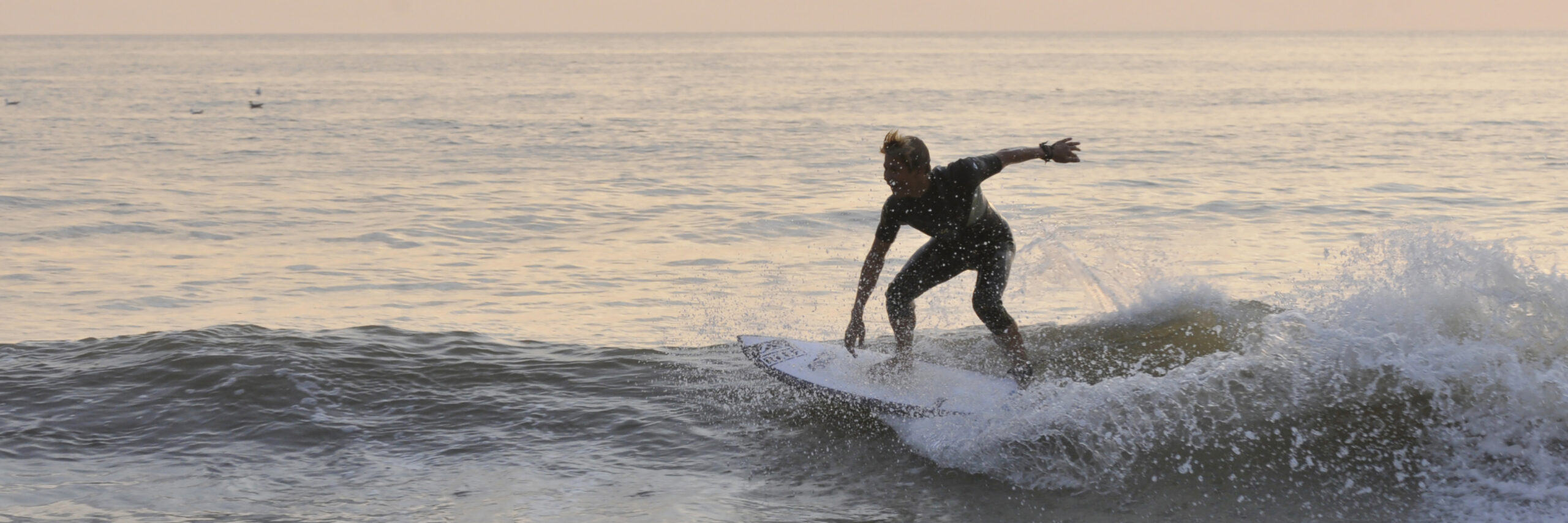 Surfer bij zonsondergang