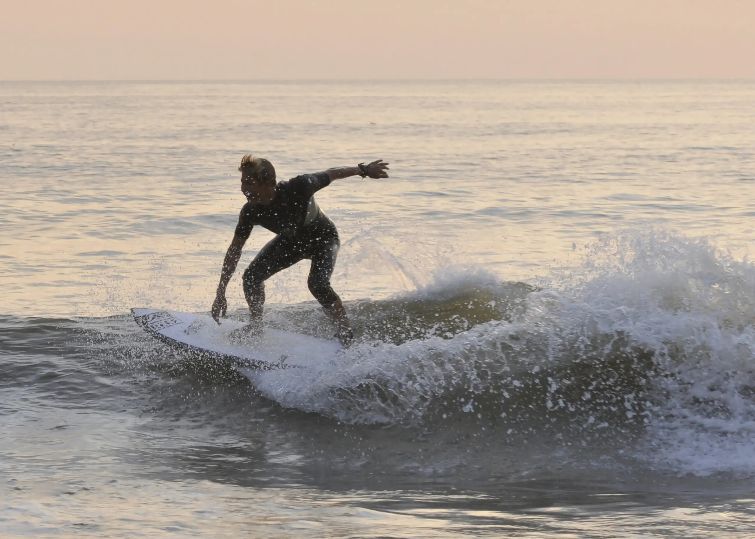 Surfer bij zonsondergang