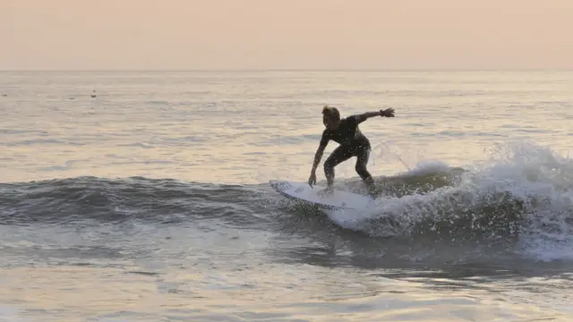 Surfer bij zonsondergang