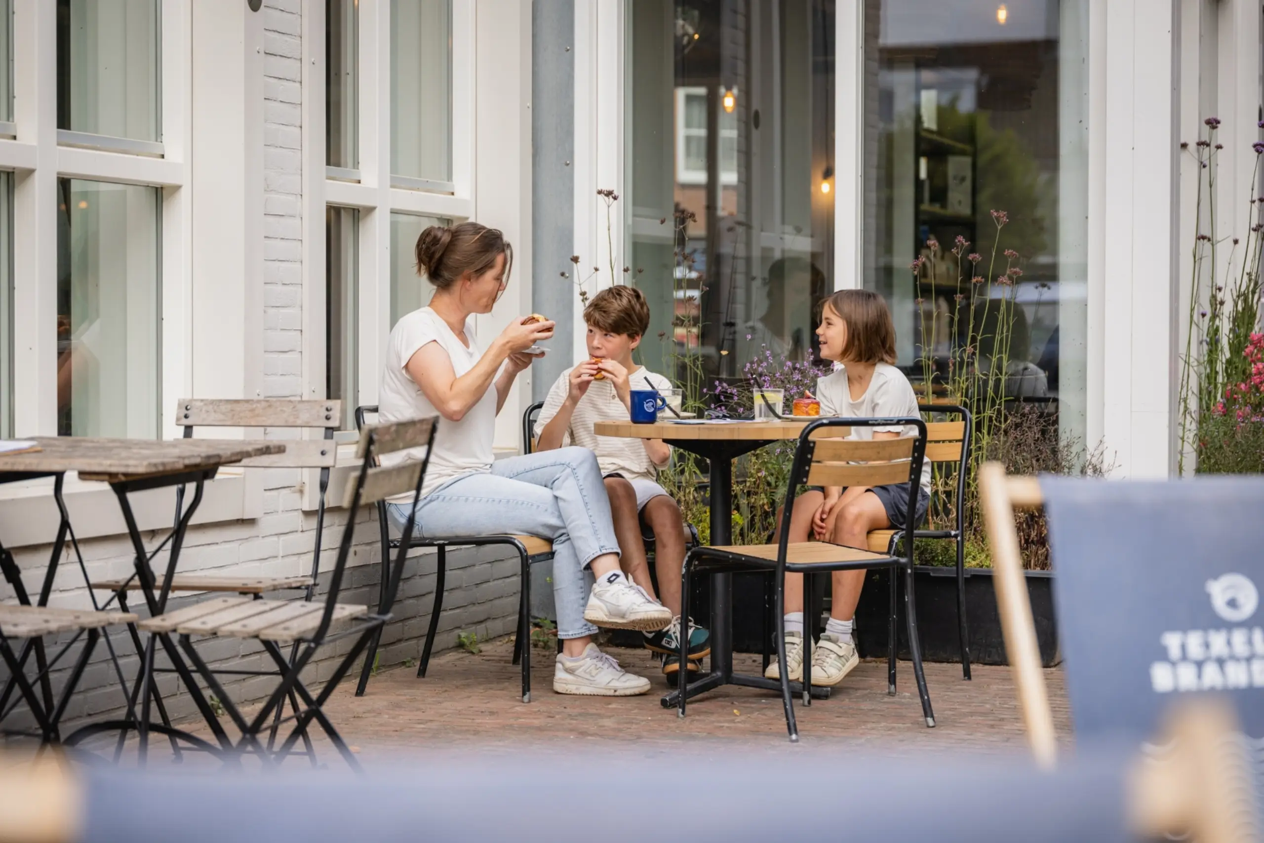 Gezin op terras bij Texelse Branding