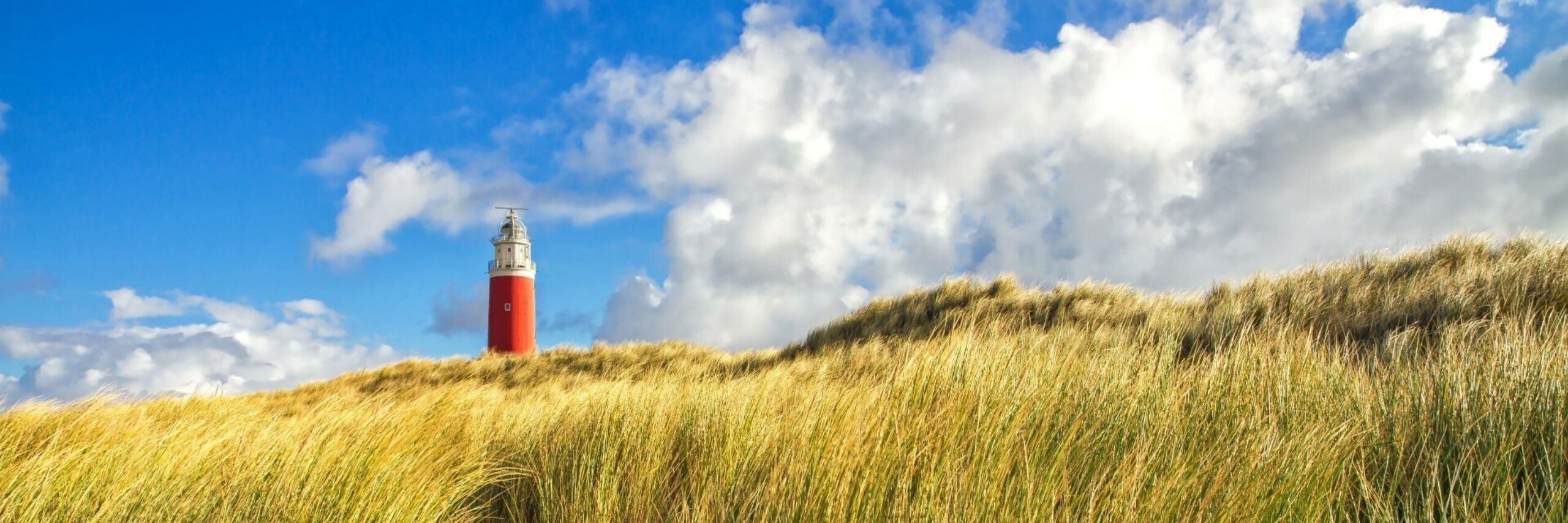 Vuurtoren met duinen en wolkenlucht VVV Texel fotograaf Justin Sinner