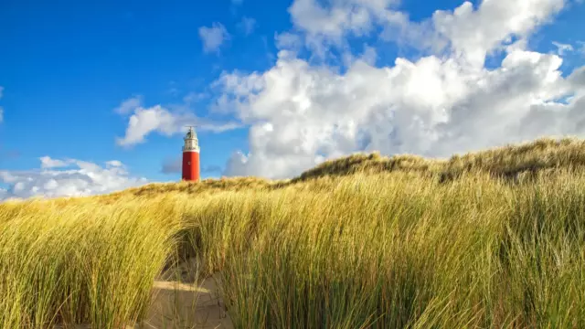 Vuurtoren met duinen en wolkenlucht VVV Texel fotograaf Justin Sinner