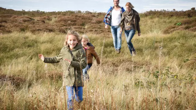 Gezin wandelt in duinen Vakantiepark De Krim