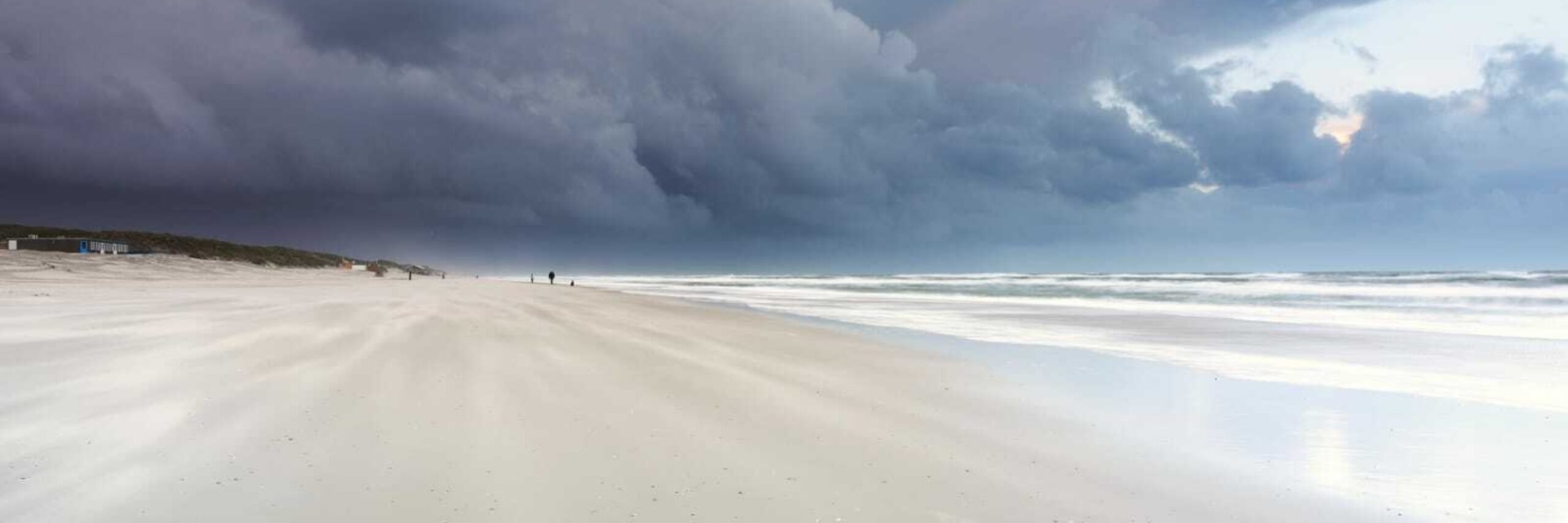 Donkere luchten boven het strand