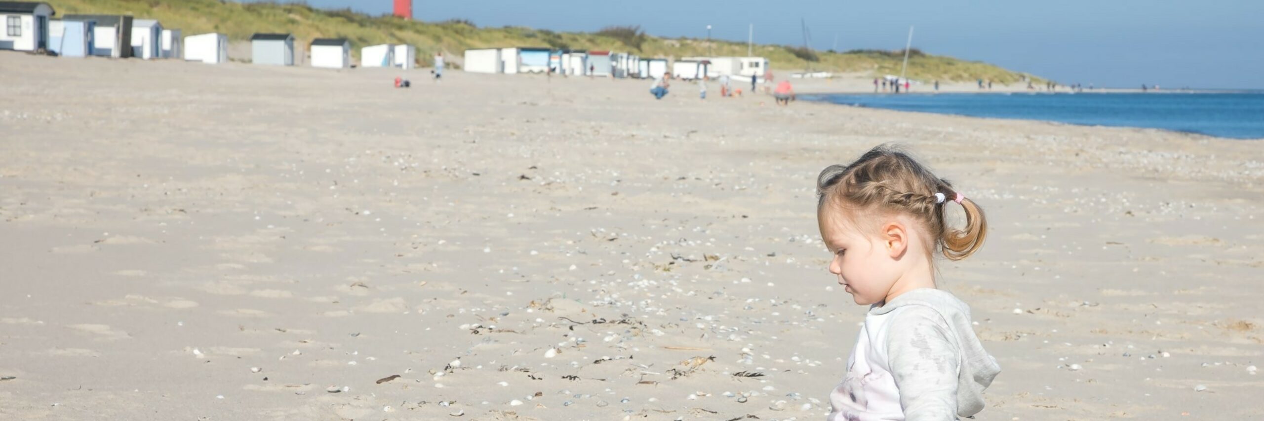 Kindje speelt op het strand bij de vuurtoren VVV Texel fotograaf Justin Sinner