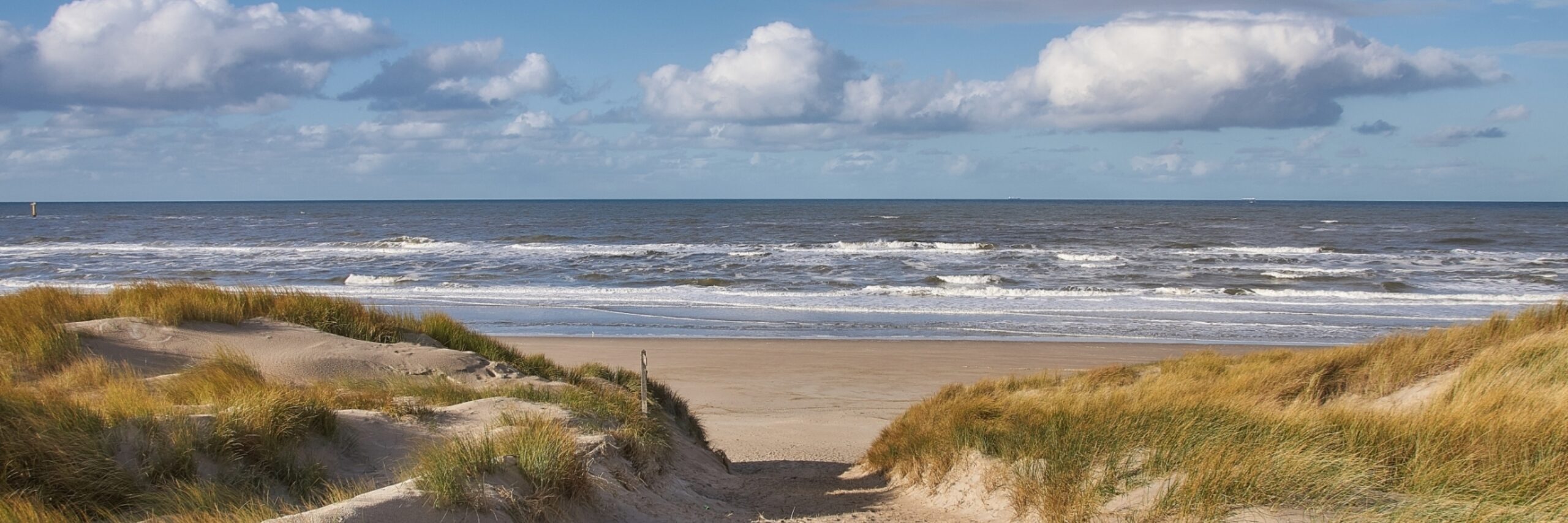 Strandopgang met wolkenlucht VVV Texel fotograaf Justin Sinner