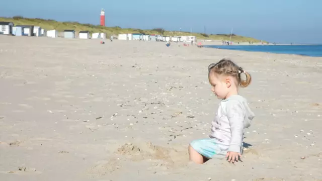 Kindje speelt op het strand bij de vuurtoren VVV Texel fotograaf Justin Sinner