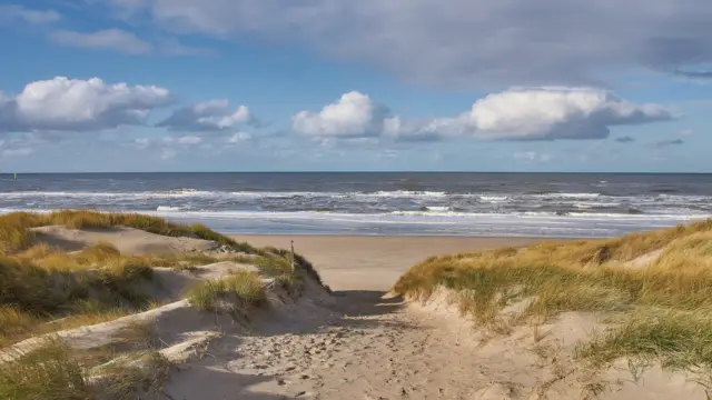 Strandopgang met wolkenlucht VVV Texel fotograaf Justin Sinner
