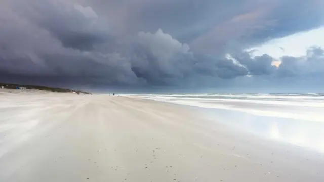 Donkere luchten boven het strand