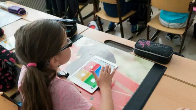 Kind in klas met i Pad voor werkstuk VVV Texel
