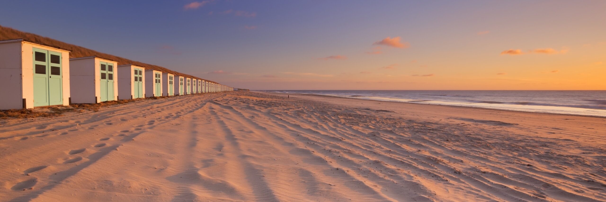 Strandhuisjes bij Paal 17 met zonsondergang