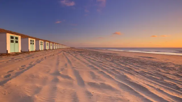 Strandhuisjes bij Paal 17 met zonsondergang