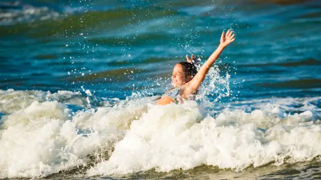 Meisje speelt in zee shutterstock 1665526813