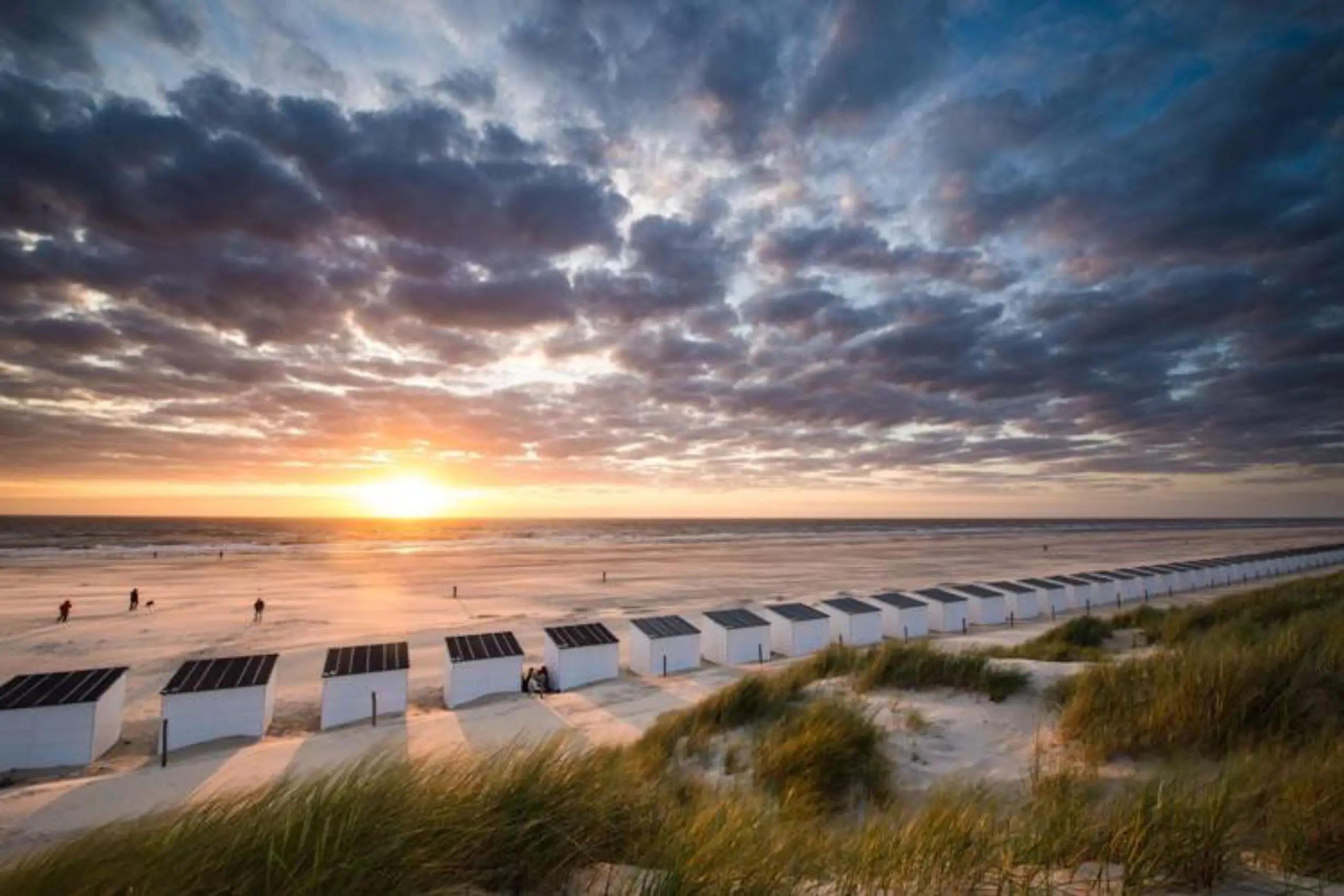 Strandhuisjes op het strand bij zonsondergang
